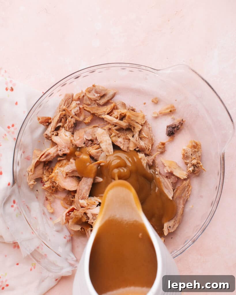 Pouring gravy into turkey leftovers.