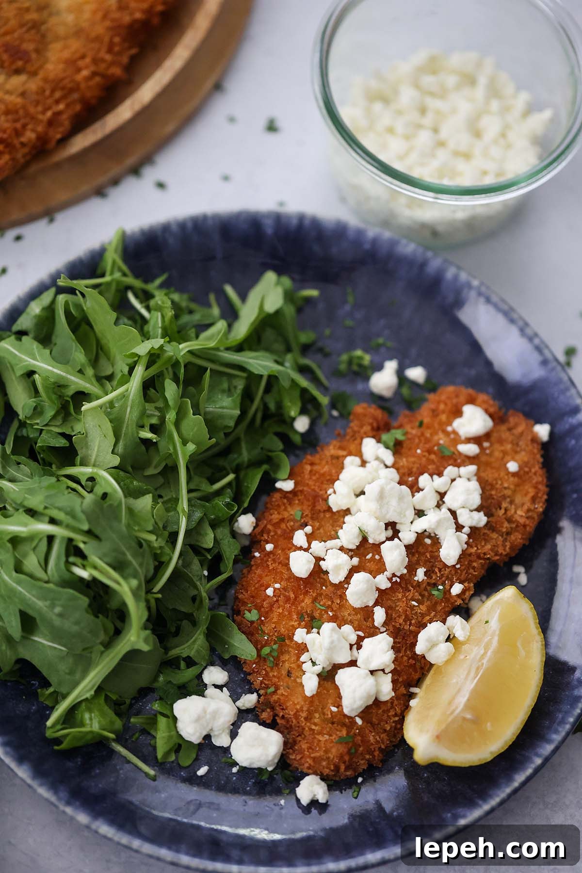 crispy chicken Milanese with goat cheese crumbles on top.