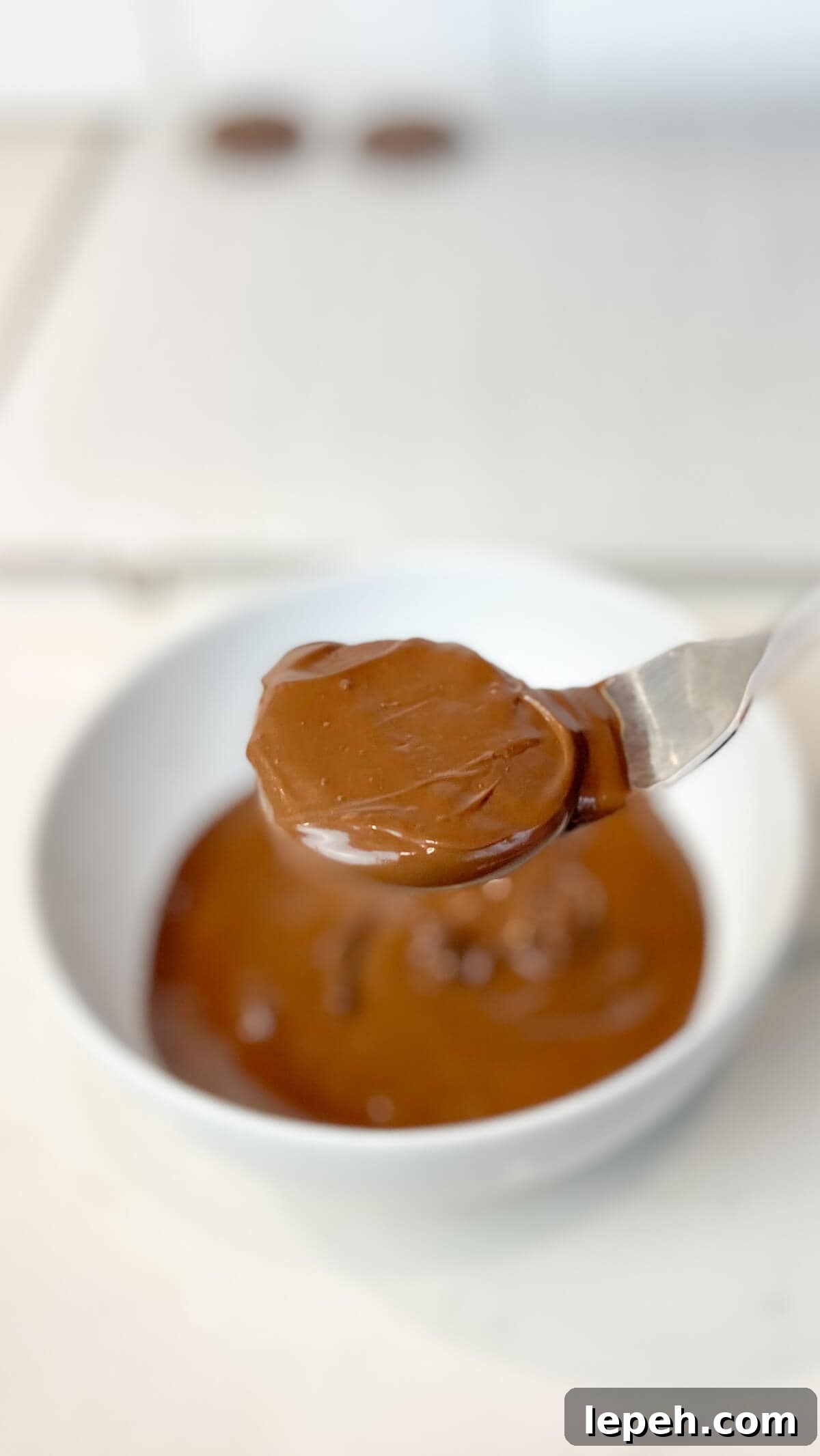 Dipping the cooled cookies in melted chocolate.