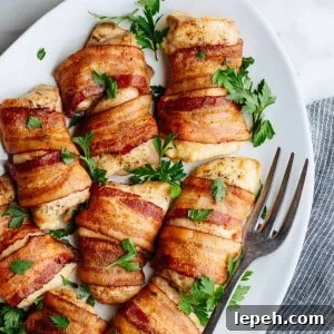 Bacon Wrapped Chicken Thighs served on a white oval platter photographed from above.