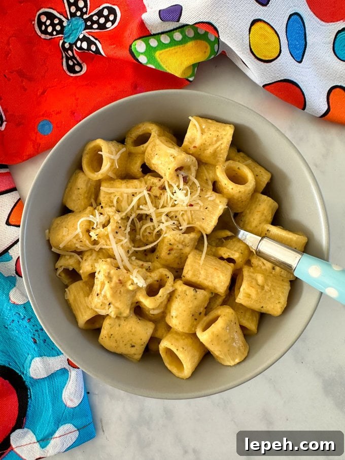 Airfryer Creamy Hidden Veg Pasta Sauce mixed with pasta and served in a light bowl bowl with a blue polka dot fork in it.