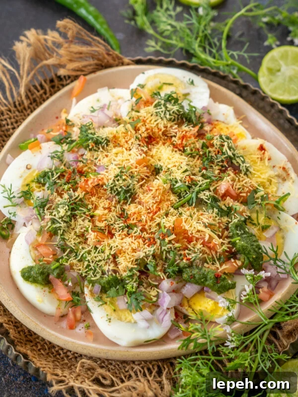 A plate of Egg Chaat topped with chopped onions, tomatoes and chutney.
