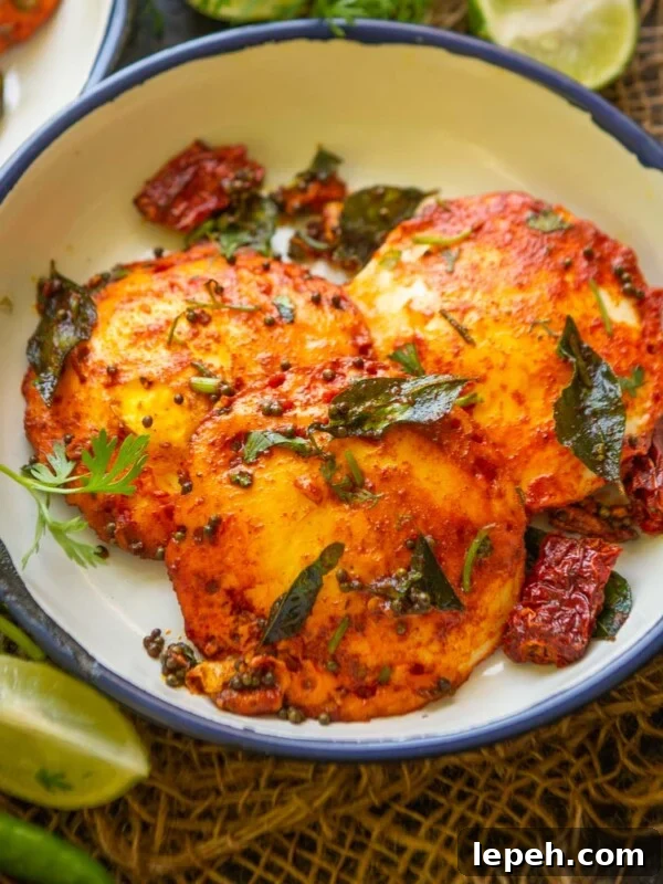 Spicy, golden-fried Egg Idli garnished with curry leaves.