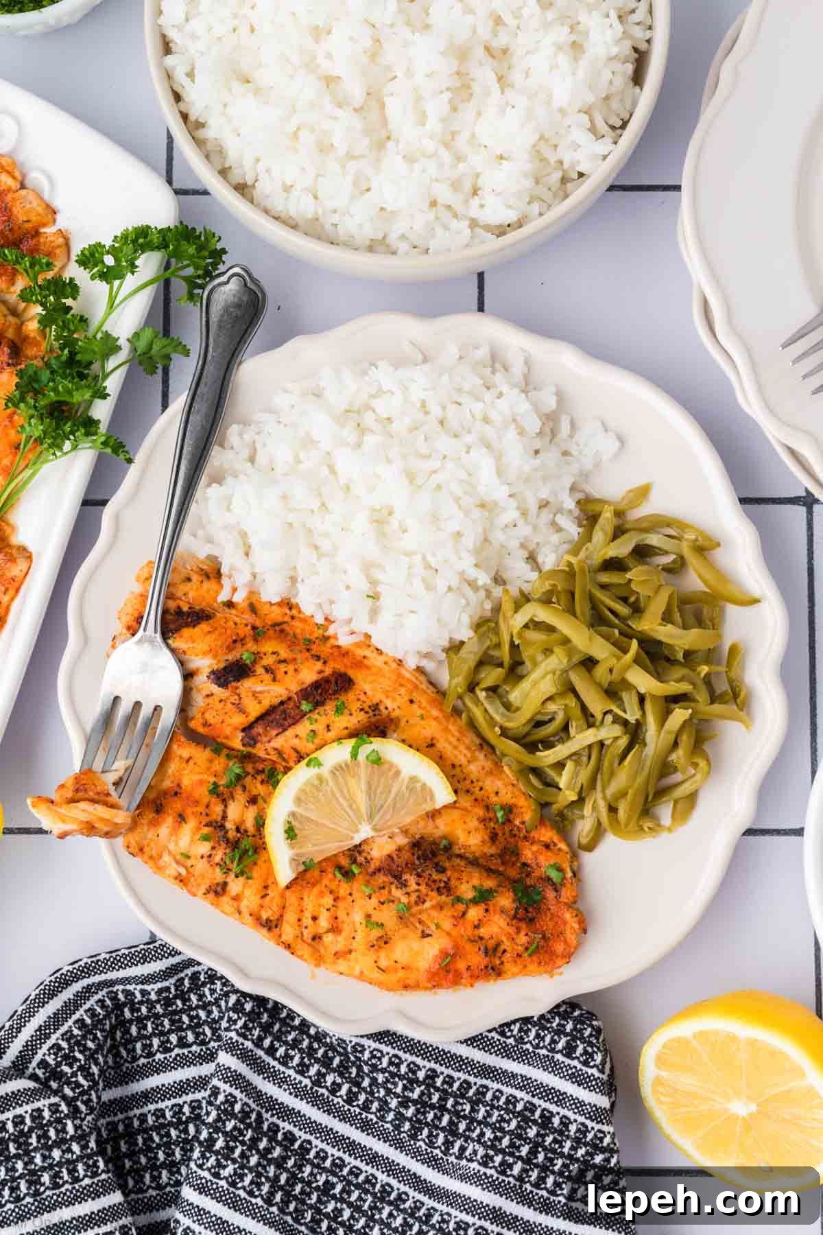 Grilled Tilapia on a plate with white rice and green beans
