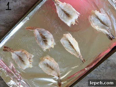 Butterfly shrimps on a baking tray.