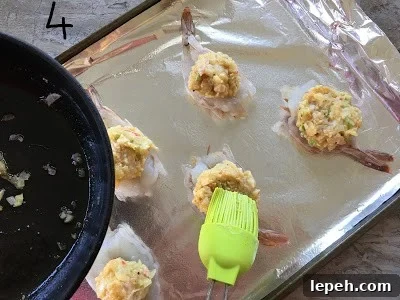 Stuffing placed on the butterfly shrimp brushed with leftover butter.