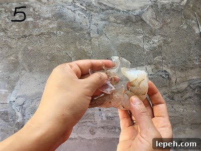 Removing the shell of the shrimp.