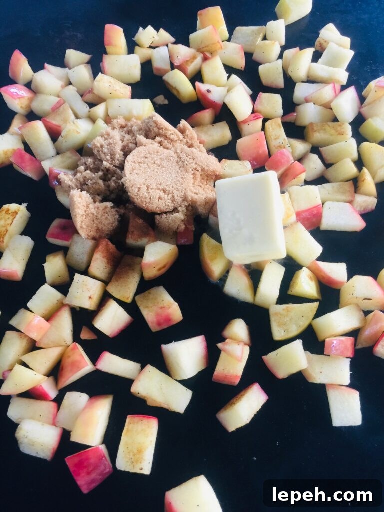 adding butter and brown sugar to apples on the griddle