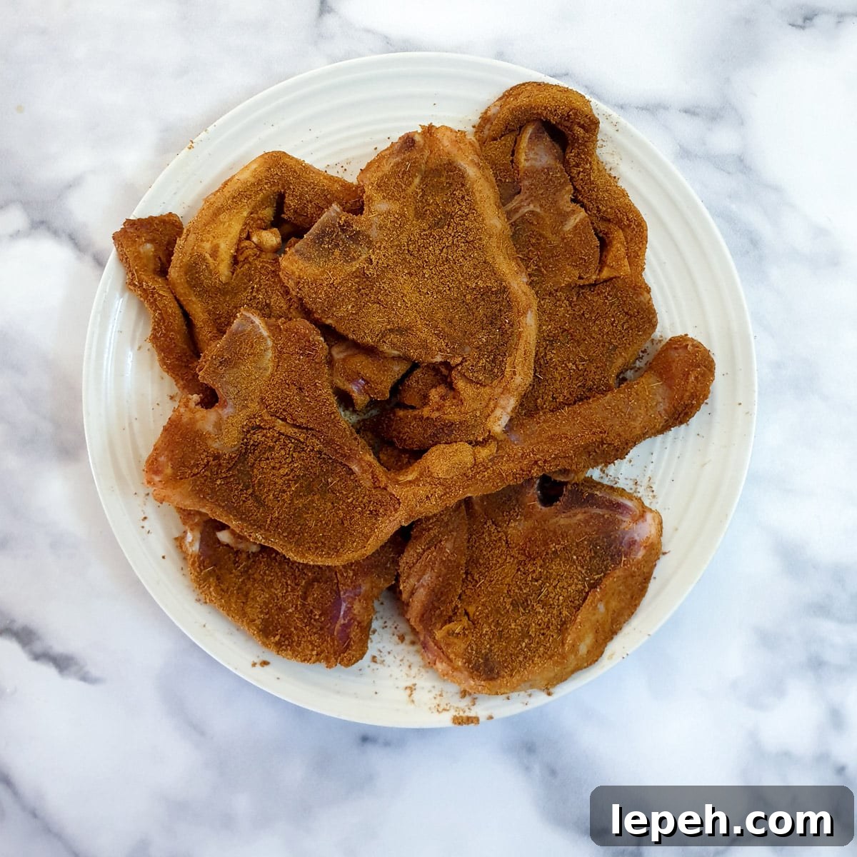 A plate of lamb chops coated with spices.