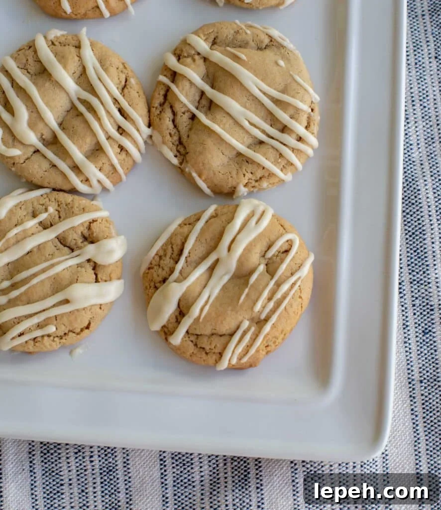 Brown sugar sourdough maple cookies drizzled with glaze and set on a white platter.