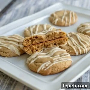 Brown sugar sourdough maple cookie broken in half and placed on a plate on top of other cookies.