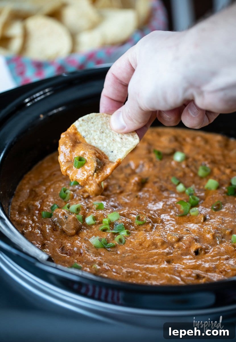 chip dipping into Hot Chili Cheese Dip