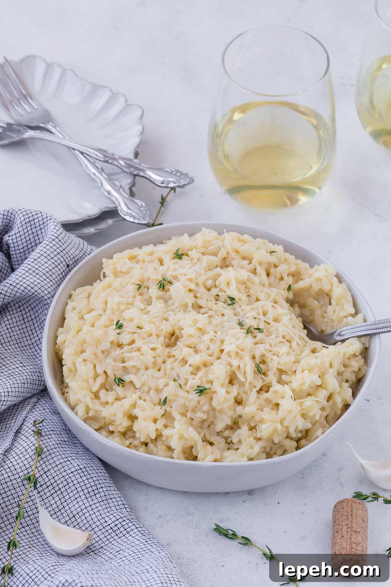 Risotto in a bowl with wine in background.
