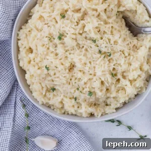 Bowl of instant pot risotto topped with parmesan cheese and fresh thyme.