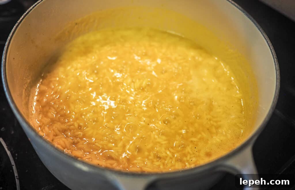 Rice pilaf simmering in a white and gray pot.