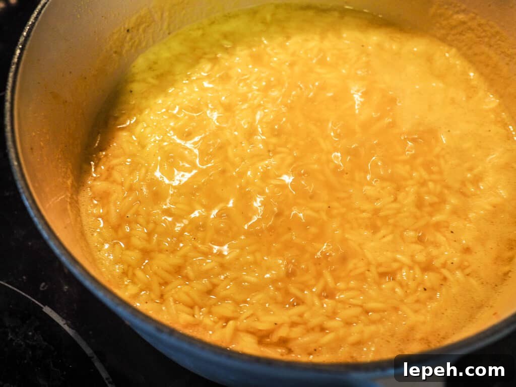 Rice pilaf simmering in a white and gray pot.