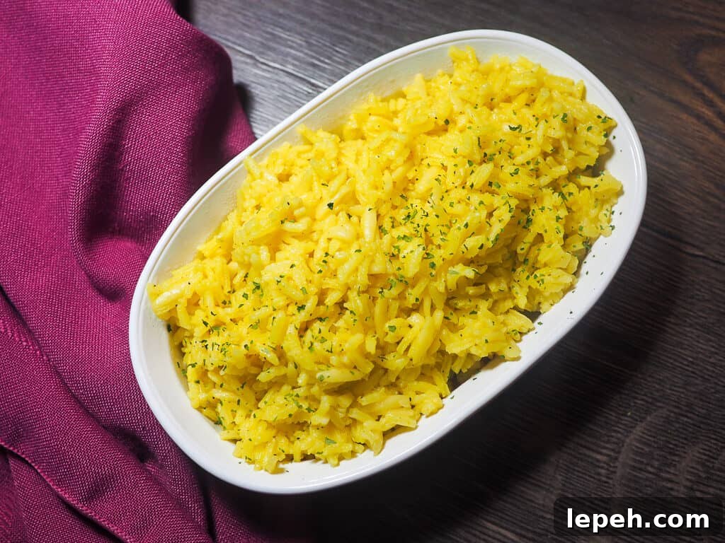 A white bowl with rice pilaf and a pink napkin.