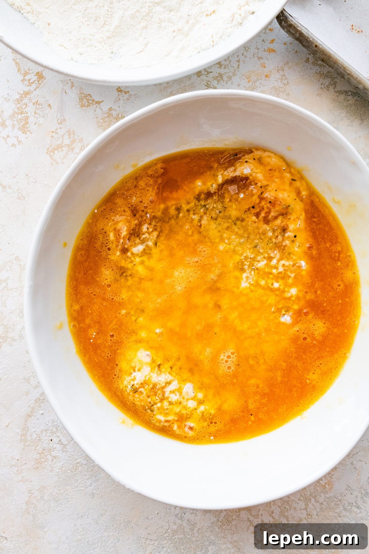 Dreading the pork chop in the egg mixture.