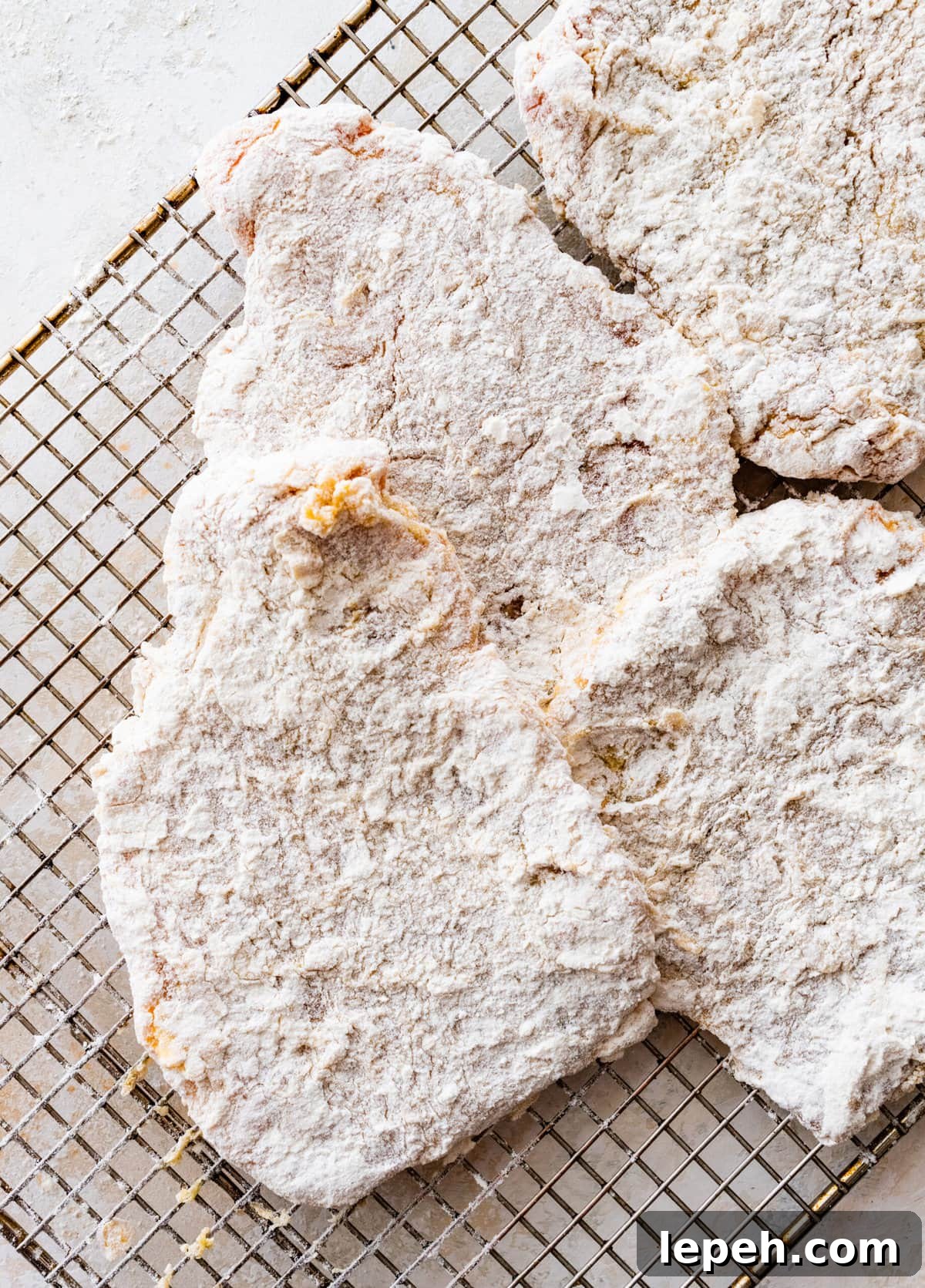 Pork chops coated in a flour egg mixture.