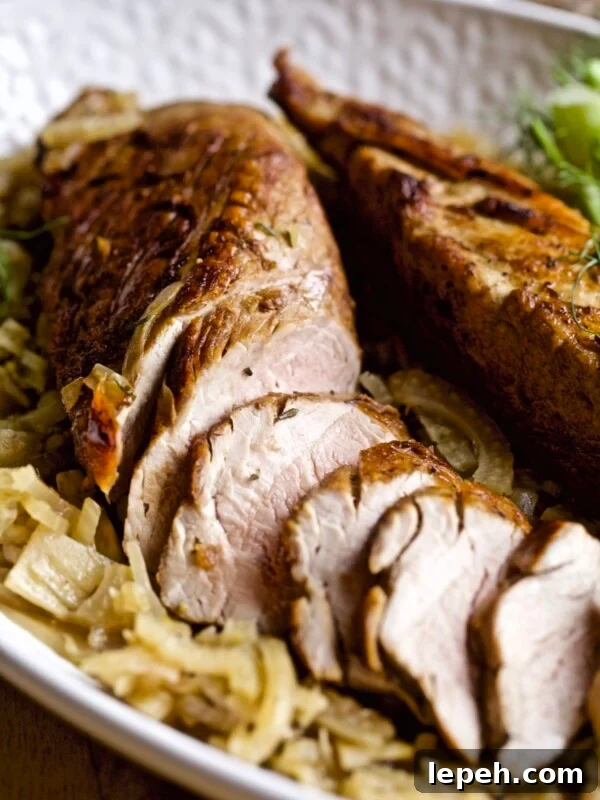 Tray with a partially-sliced pork tenderloin with fennel.