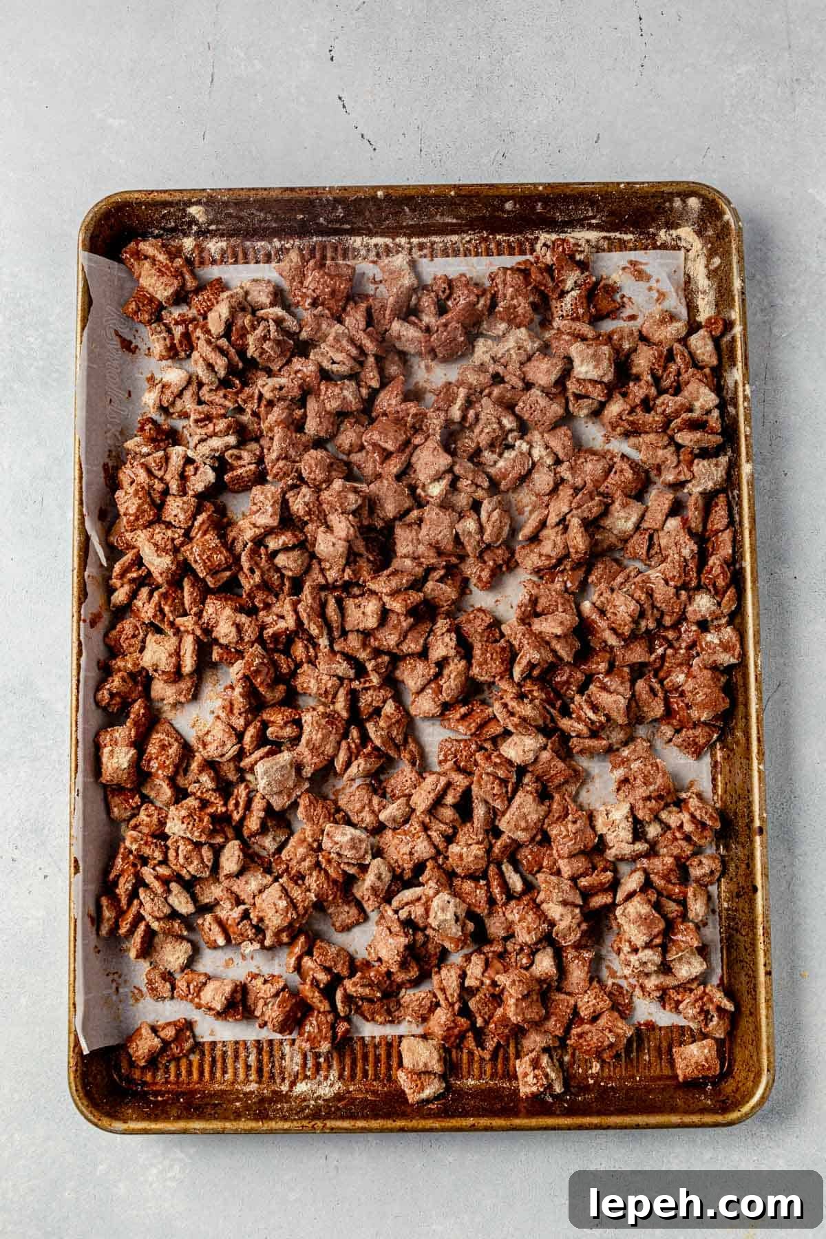protein puppy chow on a parchment lined cookie sheet