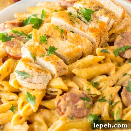 Cajun Chicken Alfredo made with penne pasta, and sliced chicken, plated.