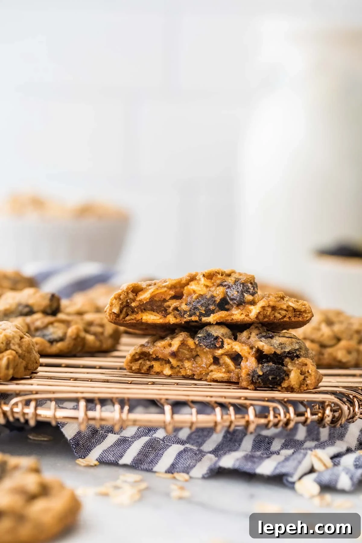 cross section of two halves of one cookie studded with raisins cooling on a metal cooling rack