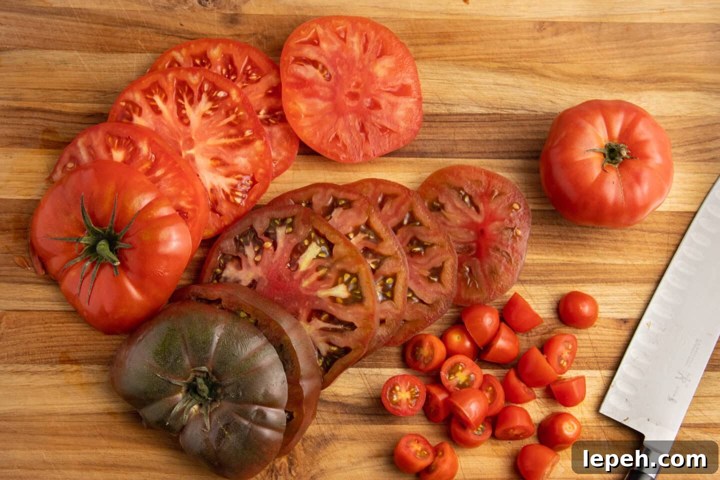 Picture of a cutting board with sliced tomatoes and a knife. 