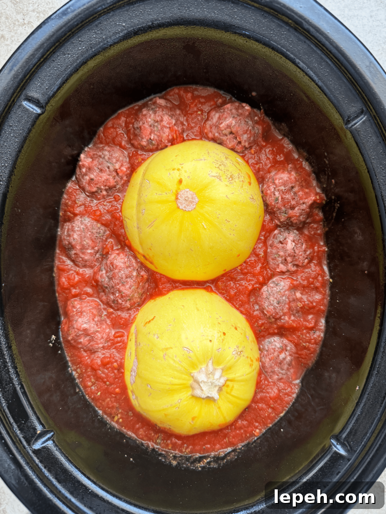 overhead shot of uncooked spaghetti squash meatballs in a black slow cooker