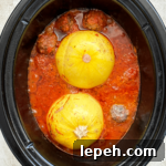 overhead shot of cooked spaghetti squash meatballs in a black slow cooker
