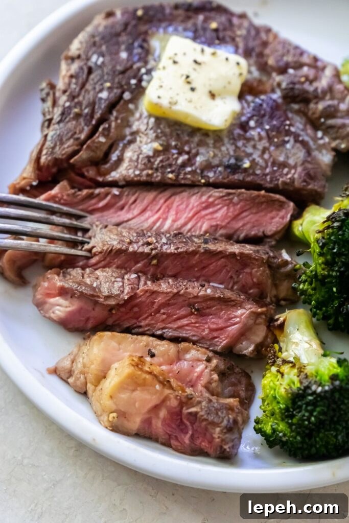 a close up shot of a sliced piece of medium rare ribeye.
