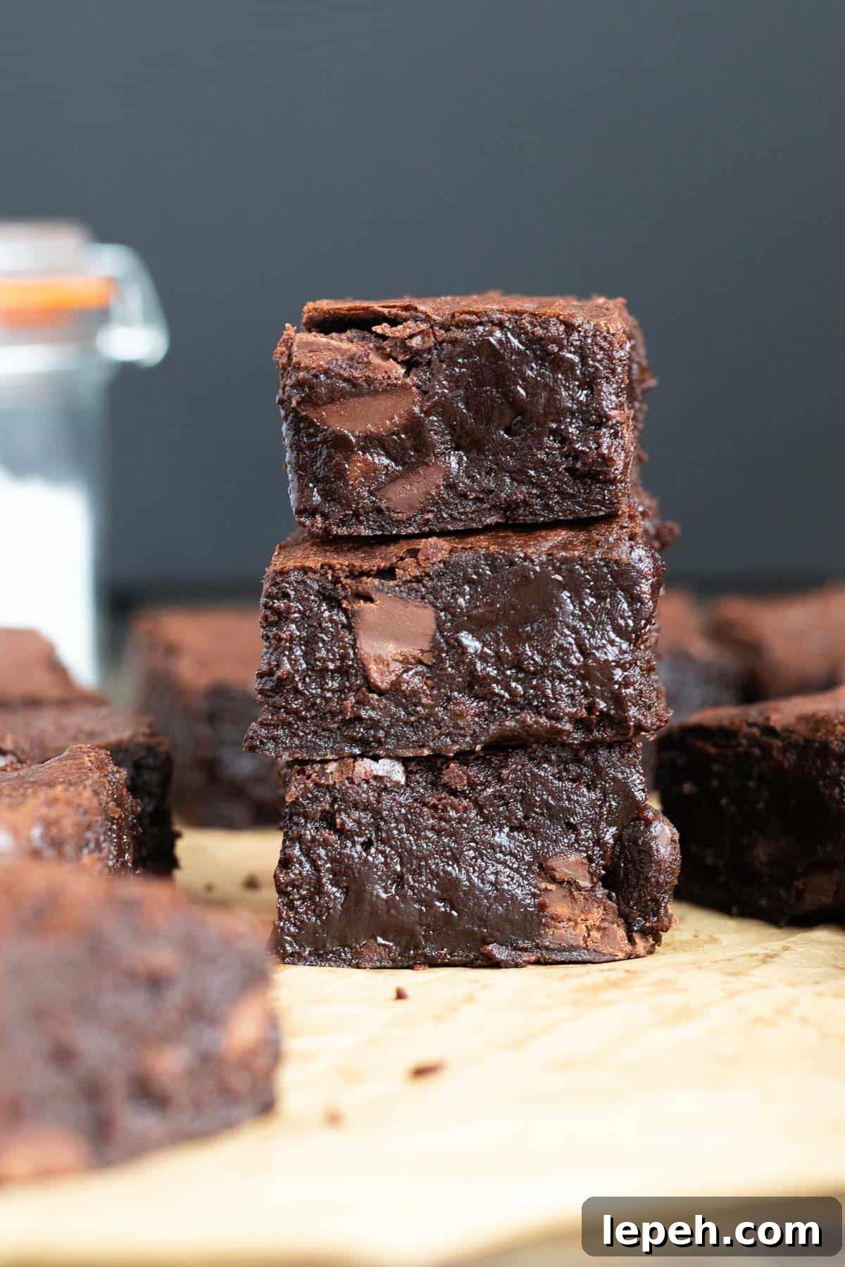 a stack of three dark chocolate brownies against a dark background