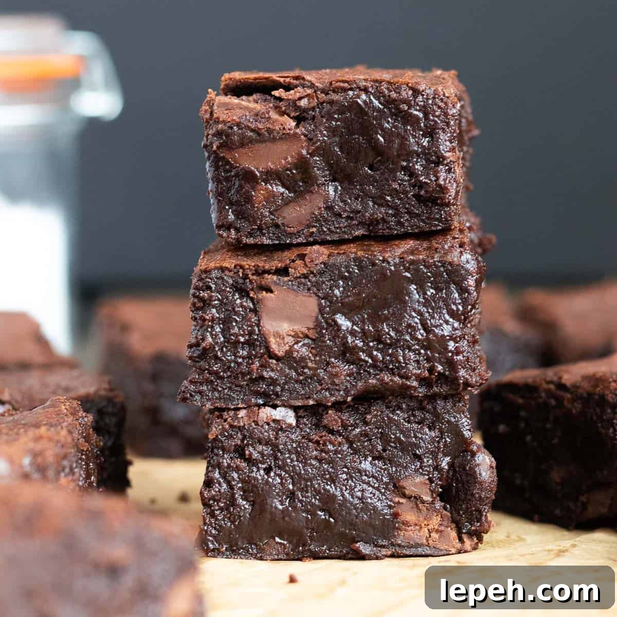 a stack of three dark chocolate brownies against a dark background