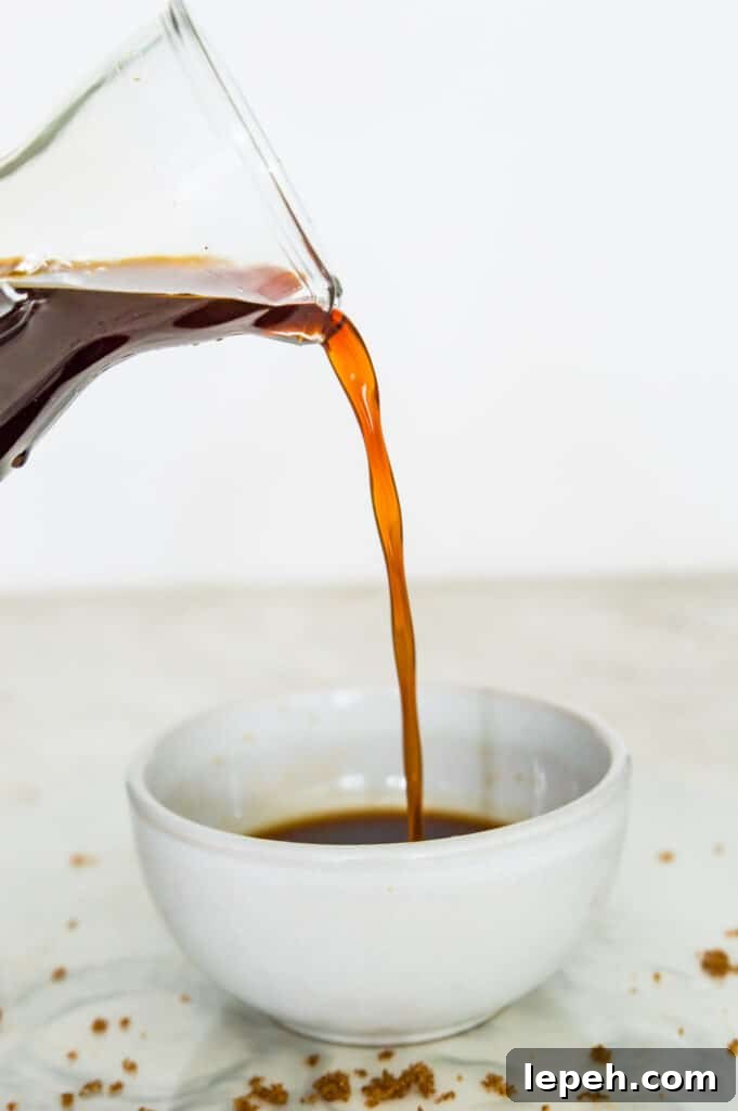 A brown syrup being poured into a bowl.