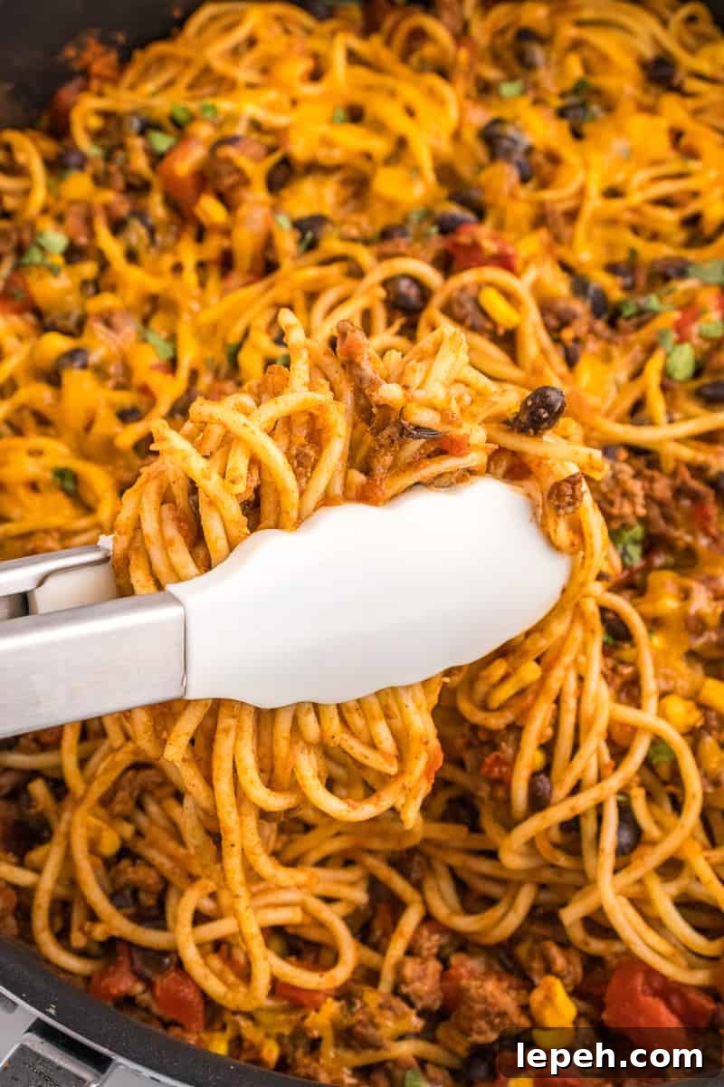 Served taco spaghetti with toppings.
