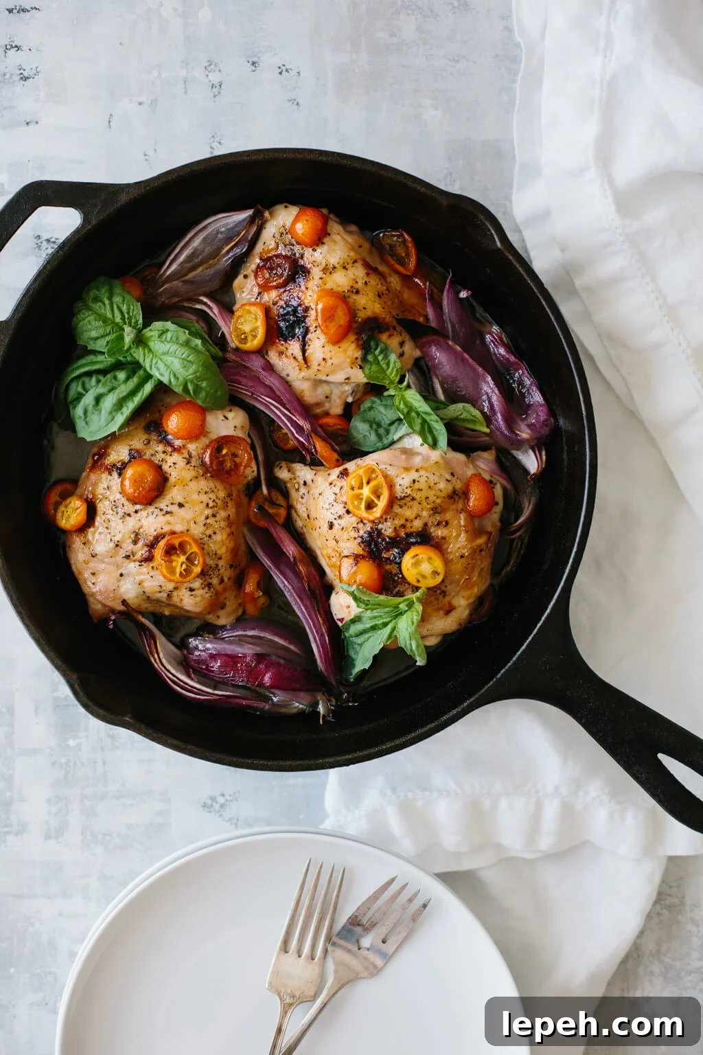 This one pan, roasted basil chicken is an easy meal that's bursting with flavor. Red onions and sliced kumquats become deliciously sweet when roasted.