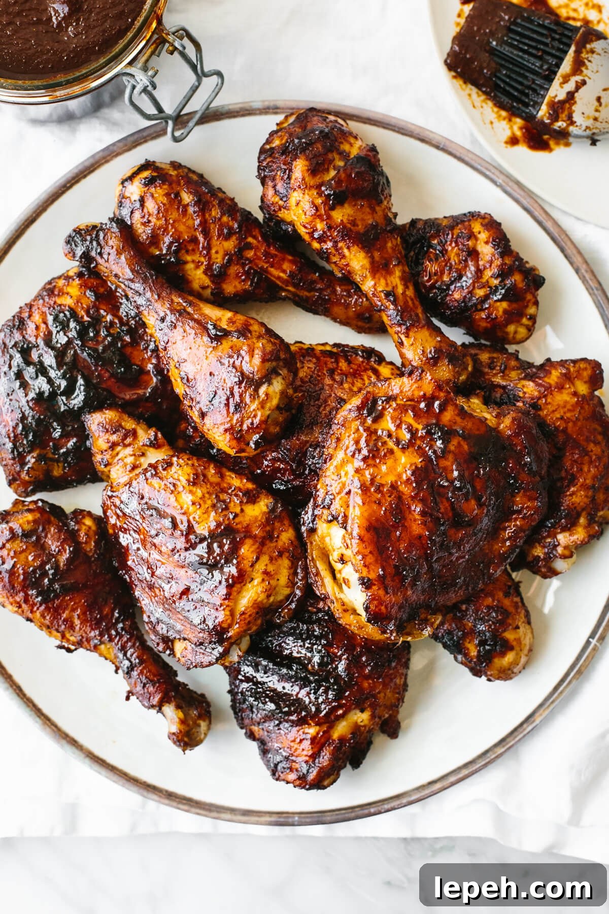A plate of BBQ chicken on a white plate and napkin.