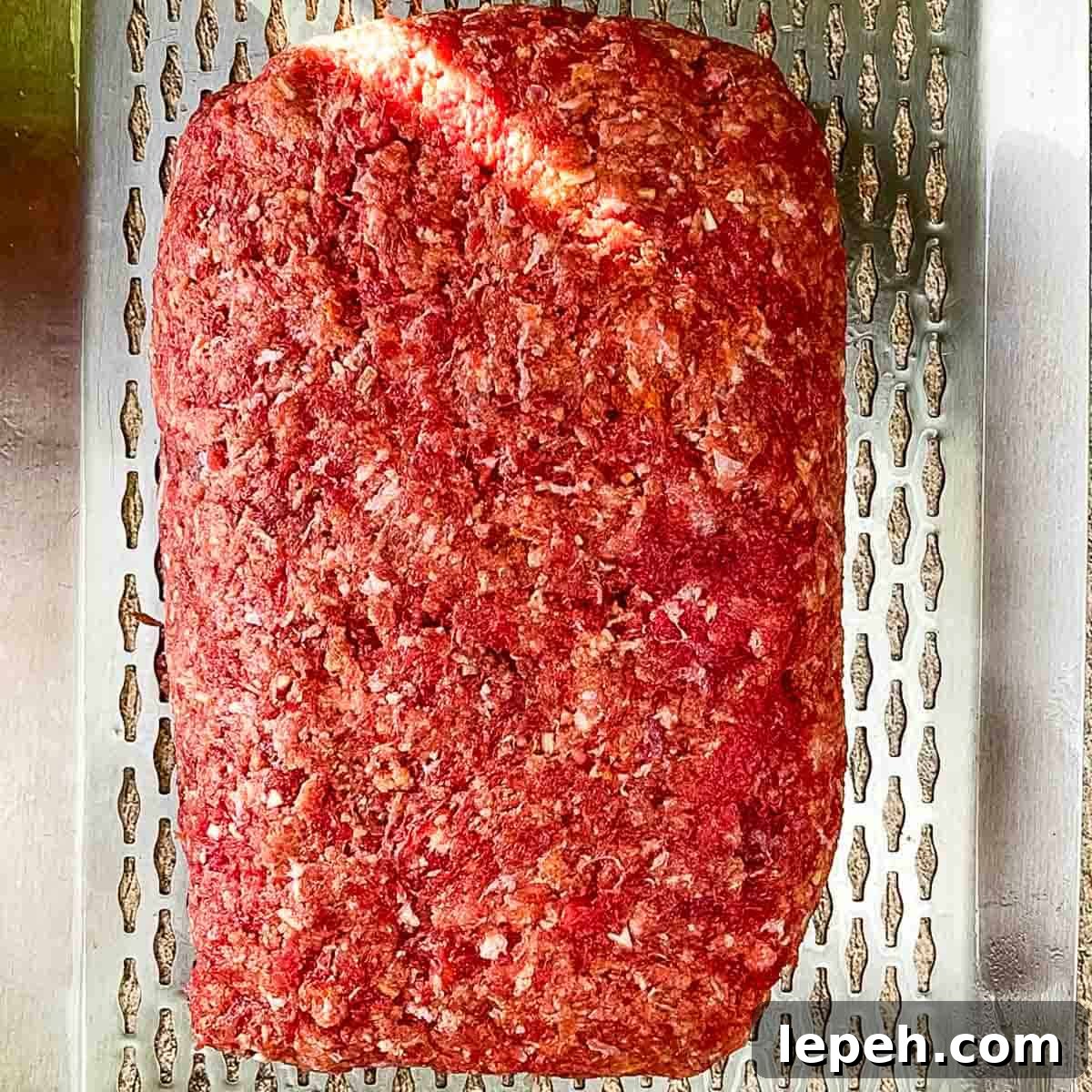The stuffed meatloaf on a grilling sheet.