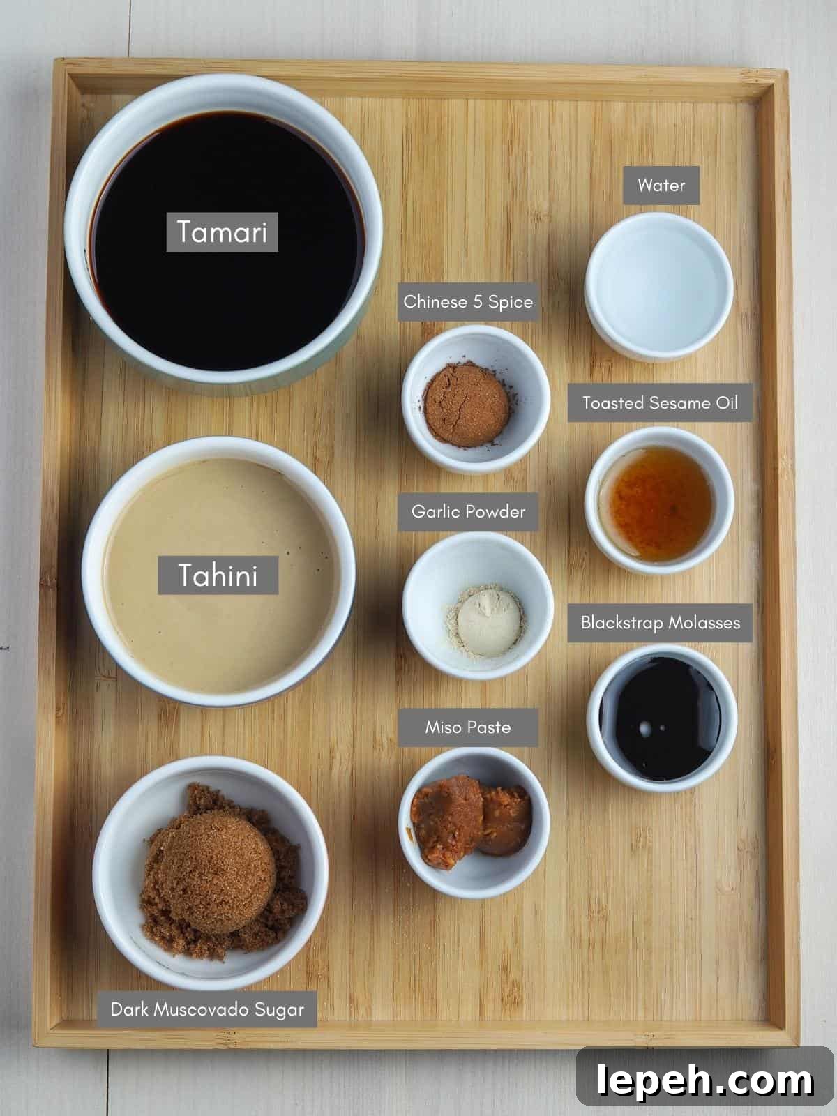 Photo showing labelled bowls of hoisin sauce ingredients on a wooden tray.
