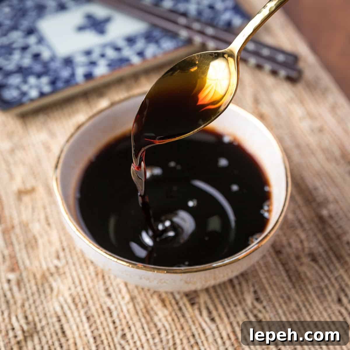 Photo of a gold teaspoon pouring teriyaki sauce