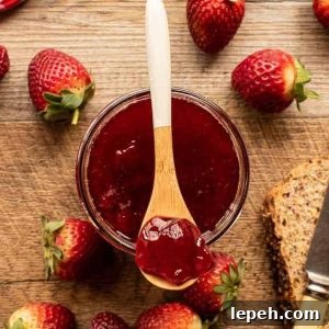 Jar of jam with strawberry jam on a spoon. strawberries and bread.