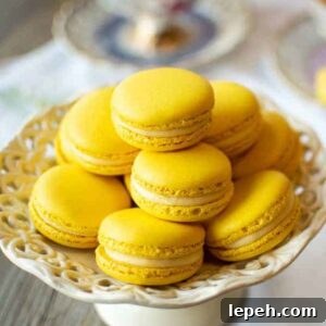 Lemon Macarons on white stand with three cups of lemon tea on a white cloth.