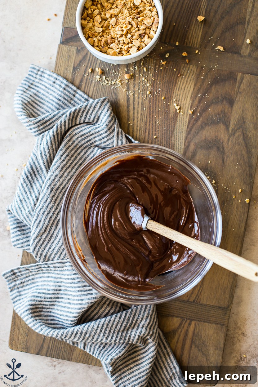 Overhead photo of a bowl of melted chocolate on a wooden board