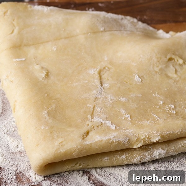 Folding rolled out pie crust pastry before placing it in a pie plate to bake.