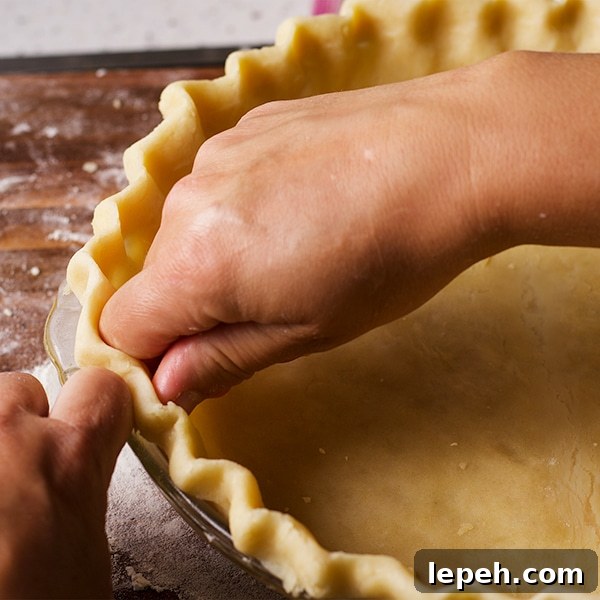 Crimping the edges of a pie crust before baking.