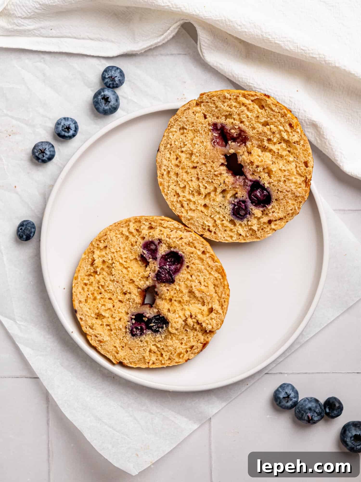 Blueberry bagel sliced in half.