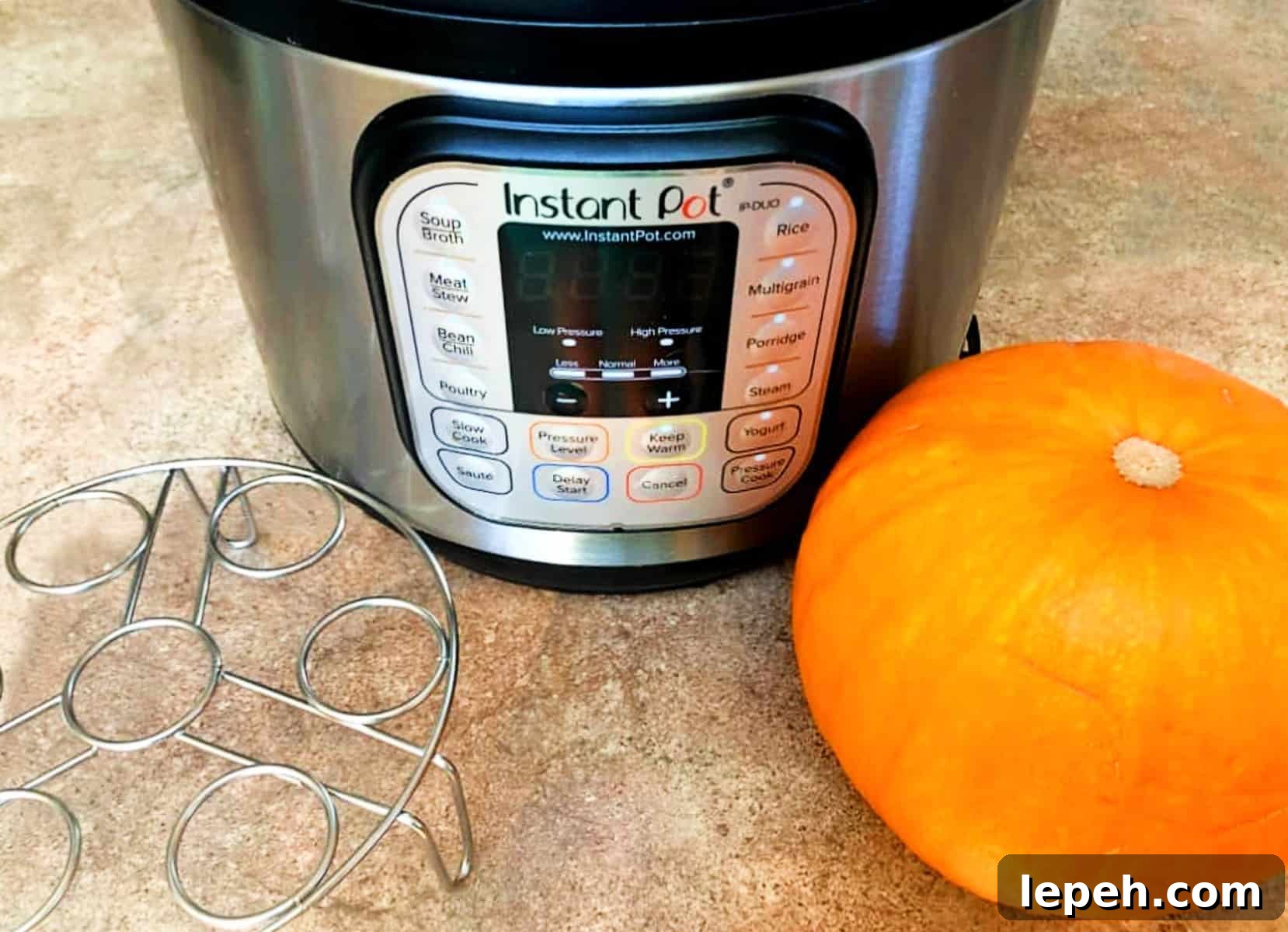 an instant pot, a pumpkin and a metal trivet