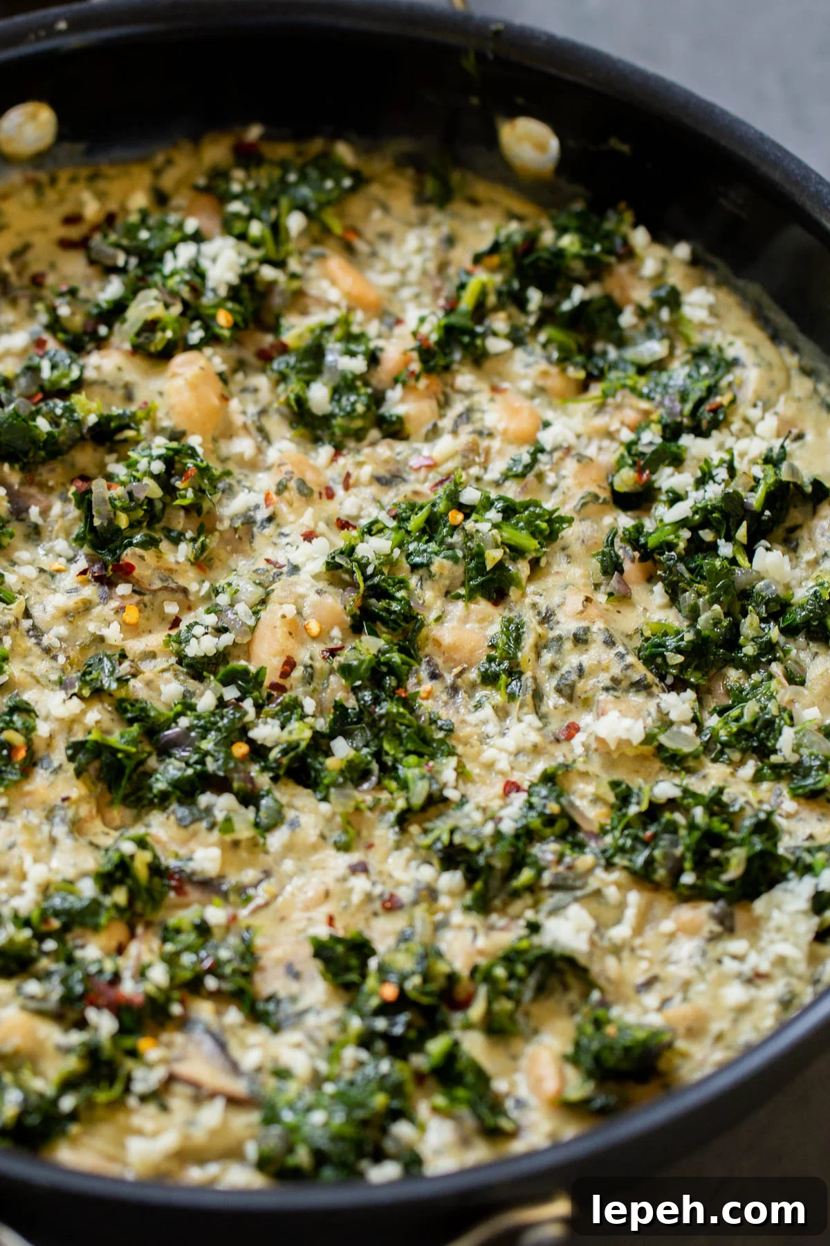 close-up of vegan white bean mushroom alfredo in the pan with spinach