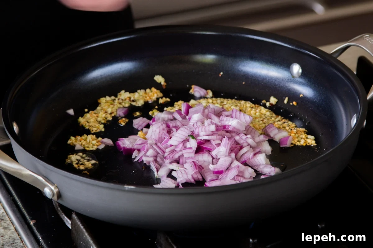 adding onions to the sautéed garlic