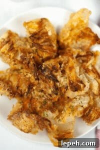A plate of crispy, golden brown air fryer blooming onions.